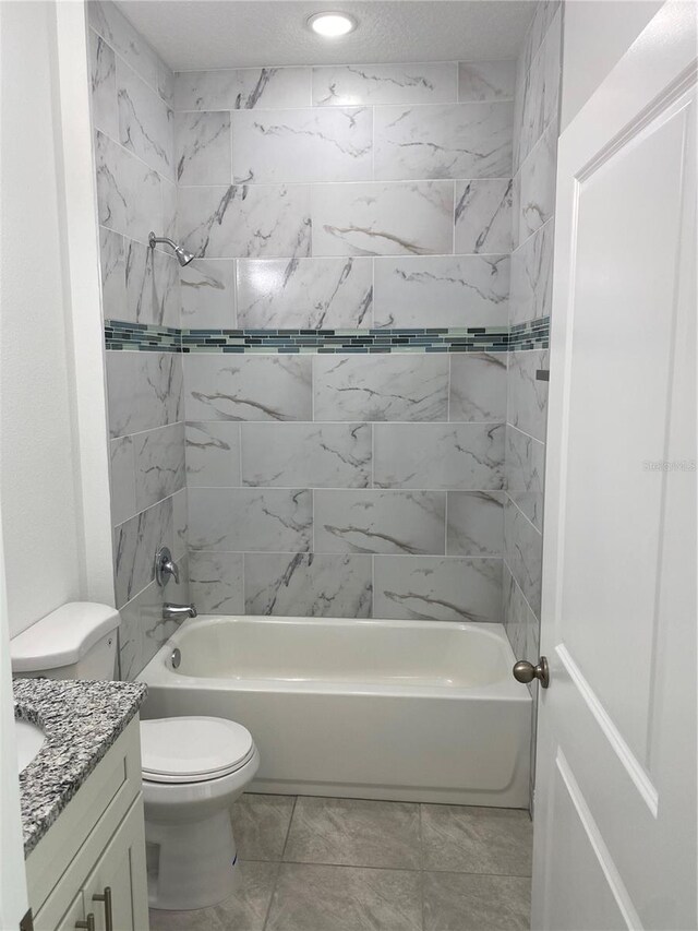 full bathroom featuring tiled shower / bath combo, toilet, and vanity