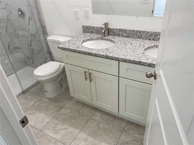 bathroom featuring toilet, vanity, and tiled shower