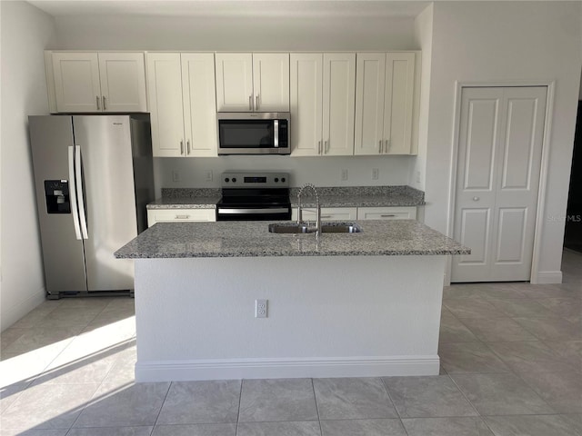 kitchen featuring sink, white cabinetry, light stone counters, and appliances with stainless steel finishes