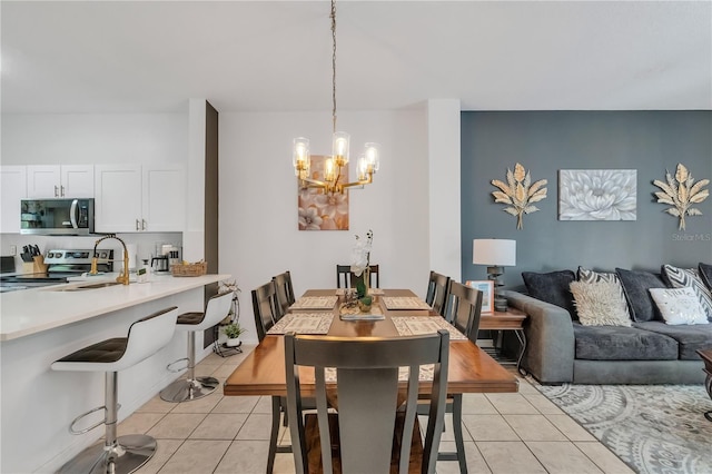 dining area featuring an inviting chandelier, sink, and light tile patterned floors