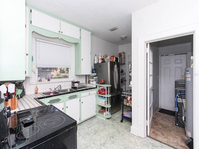 kitchen featuring white cabinets, tasteful backsplash, gas water heater, black / electric stove, and sink