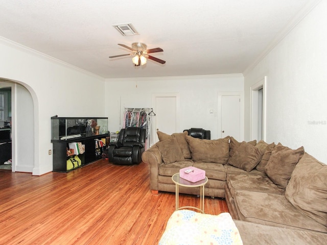 living room with ceiling fan, wood-type flooring, and ornamental molding