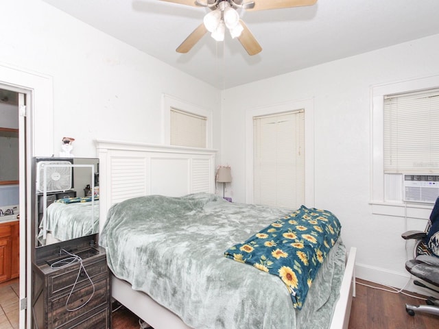 bedroom featuring ceiling fan, cooling unit, and dark hardwood / wood-style floors