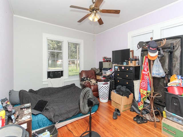 bedroom with ceiling fan, hardwood / wood-style flooring, and ornamental molding