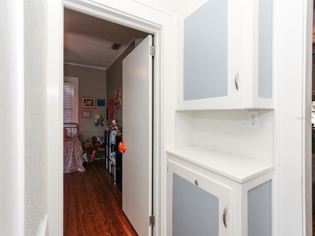 corridor featuring crown molding and dark hardwood / wood-style flooring