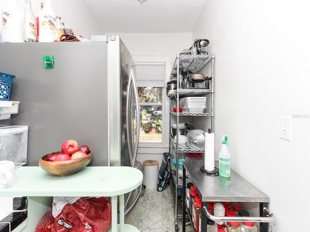 interior space with concrete floors and stainless steel refrigerator