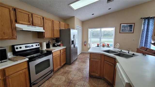 kitchen featuring light tile patterned flooring, sink, a textured ceiling, appliances with stainless steel finishes, and vaulted ceiling