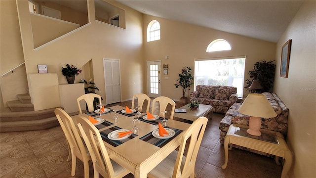 tiled dining room featuring high vaulted ceiling