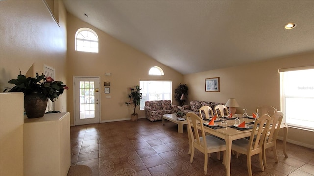 dining space featuring tile patterned flooring and high vaulted ceiling