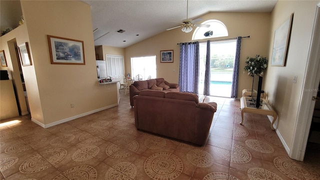 living room with light tile patterned floors, vaulted ceiling, ceiling fan, and plenty of natural light