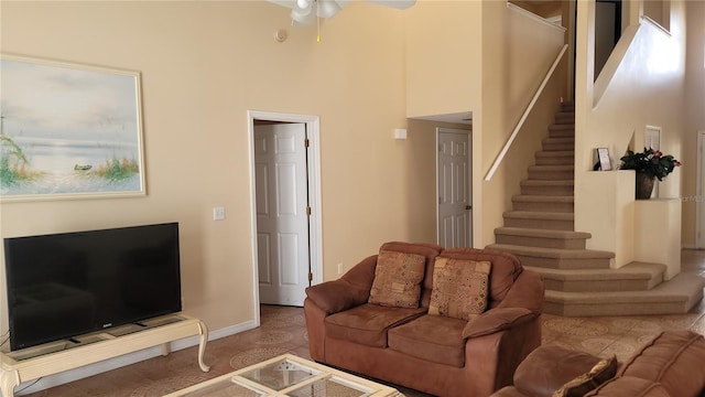 tiled living room with a high ceiling and ceiling fan