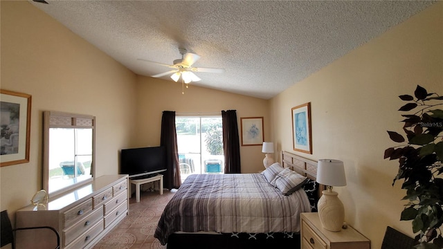 bedroom with a textured ceiling, lofted ceiling, and ceiling fan