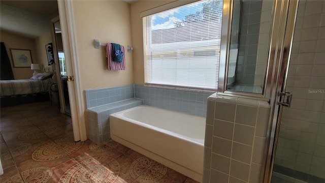 bathroom with tile walls, shower with separate bathtub, and tile patterned floors