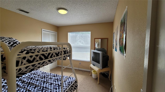 carpeted bedroom featuring a textured ceiling