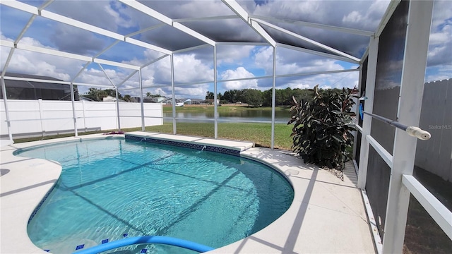 view of swimming pool featuring a patio, glass enclosure, and a water view