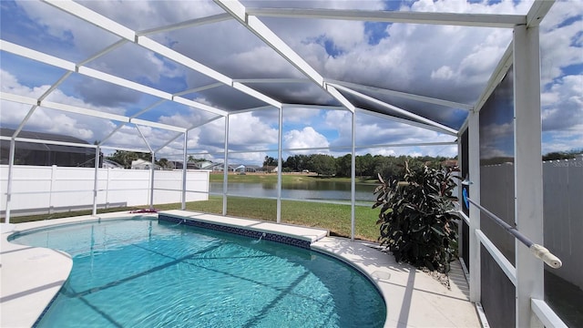 view of pool with glass enclosure and a water view