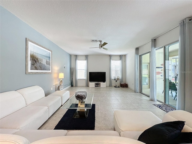 tiled living room featuring a textured ceiling and ceiling fan