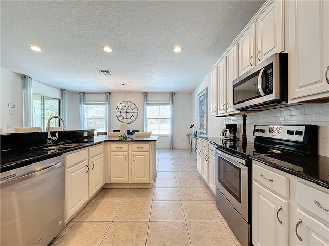 kitchen with white cabinetry, stainless steel appliances, tasteful backsplash, and sink