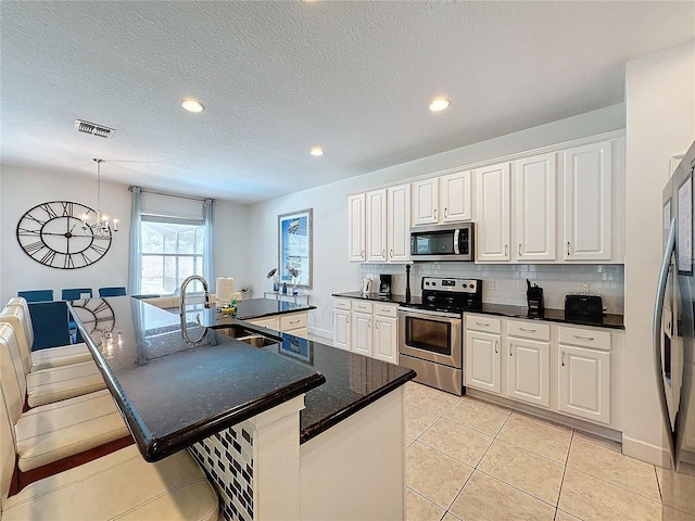 416 Orange Cosmos Blvd, Davenport, FL 33837 - kitchen with appliances with stainless steel finishes, a sink, a chandelier, decorative backsplash, and white cabinetry