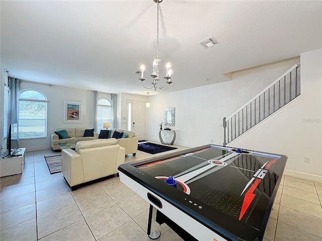 game room featuring light tile patterned floors and a chandelier