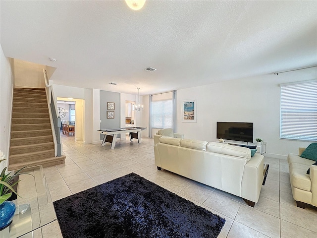 416 Orange Cosmos Blvd, Davenport, FL 33837 - living area with light tile patterned flooring, stairway, a chandelier, and a textured ceiling