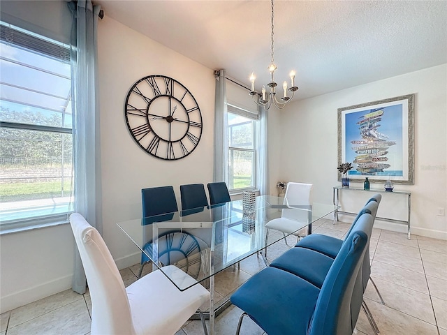 dining area featuring a textured ceiling, light tile patterned flooring, and an inviting chandelier