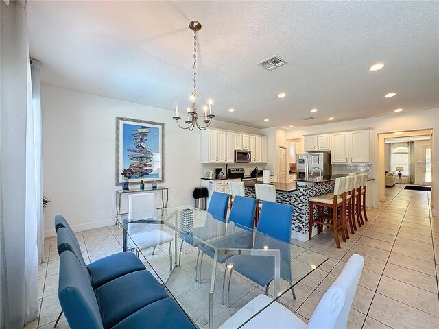 416 Orange Cosmos Blvd, Davenport, FL 33837 - dining space featuring a chandelier, light tile patterned flooring, recessed lighting, baseboards, and a textured ceiling