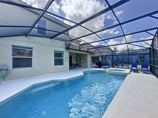 view of pool with an in ground hot tub, glass enclosure, and a patio