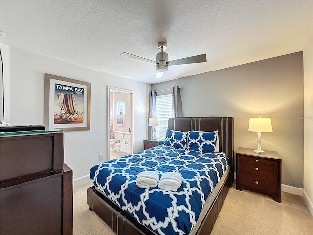 carpeted bedroom with ceiling fan, a textured ceiling, and ensuite bathroom