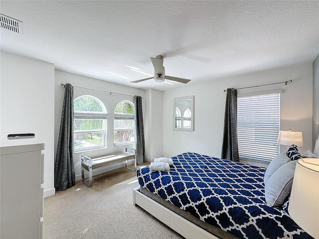 bedroom featuring a textured ceiling, carpet flooring, and ceiling fan