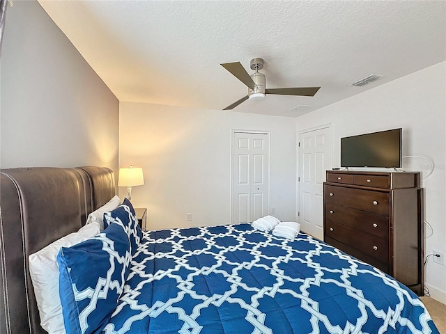 bedroom featuring ceiling fan, carpet, and a textured ceiling