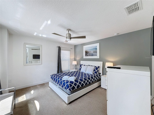 carpeted bedroom with a textured ceiling and ceiling fan