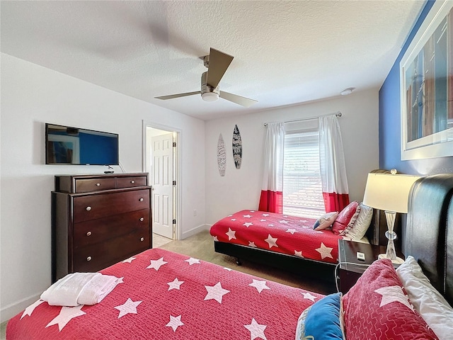 carpeted bedroom featuring ceiling fan and a textured ceiling