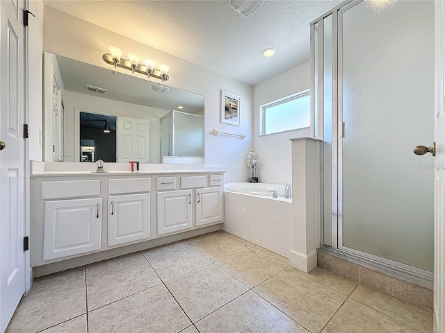 bathroom with tile patterned flooring, plus walk in shower, and a textured ceiling