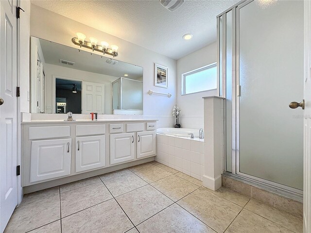 416 Orange Cosmos Blvd, Davenport, FL 33837 - full bath with a stall shower, a garden tub, double vanity, a textured ceiling, and tile patterned floors