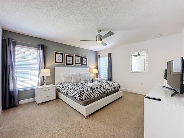 carpeted bedroom featuring a textured ceiling and ceiling fan