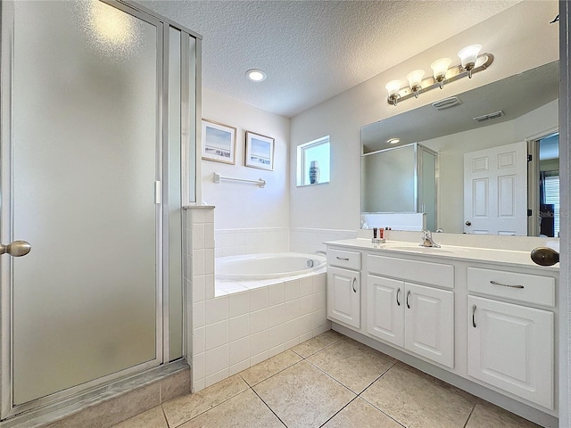 bathroom with shower with separate bathtub, a textured ceiling, tile patterned flooring, and vanity