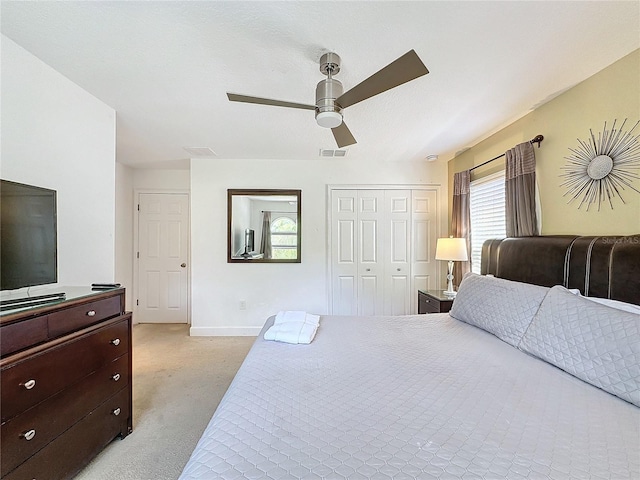 bedroom with light carpet, ceiling fan, and a closet