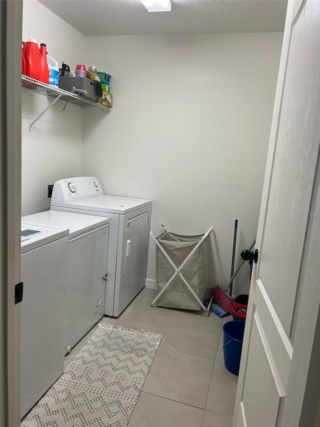 washroom with washer and clothes dryer and a textured ceiling