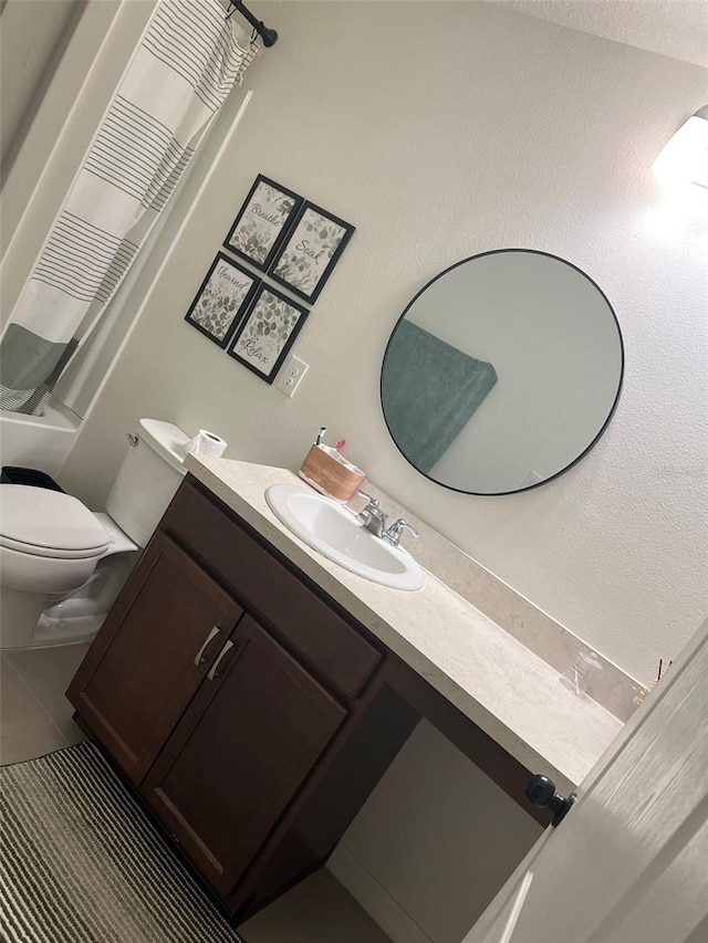 full bathroom featuring tile patterned floors, vanity, shower / bath combination with curtain, and toilet