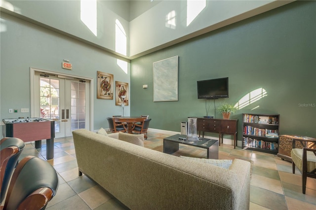 living room with french doors, light tile patterned flooring, and a high ceiling