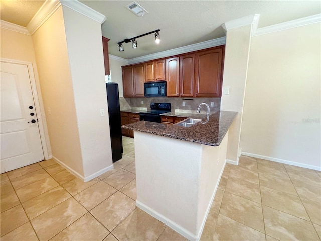 kitchen featuring decorative backsplash, kitchen peninsula, dark stone countertops, sink, and black appliances