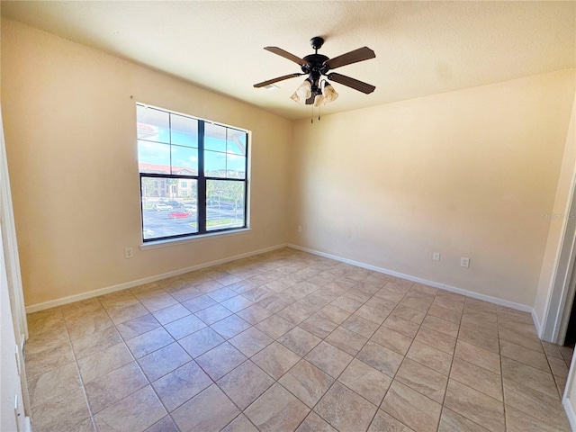 tiled empty room featuring a textured ceiling and ceiling fan