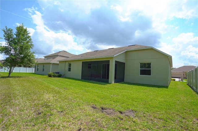 back of property featuring a sunroom and a yard