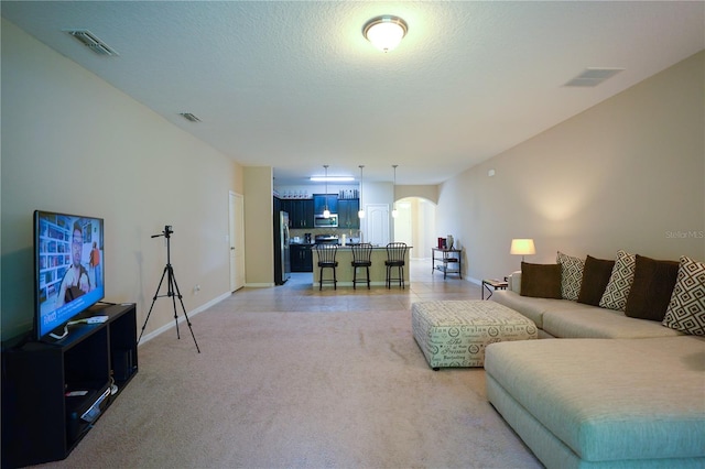 living room featuring a textured ceiling and light carpet