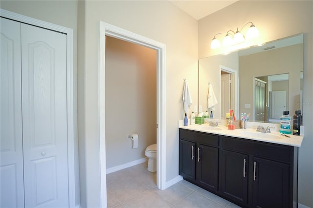 bathroom with tile patterned flooring, vanity, and toilet