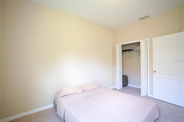 bedroom with light colored carpet and a closet