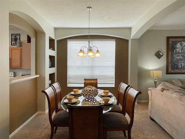 carpeted dining area featuring a notable chandelier and a textured ceiling