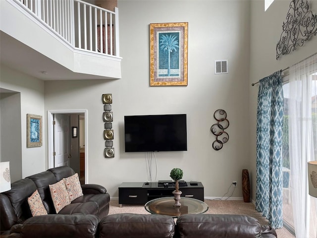 carpeted living room featuring a high ceiling