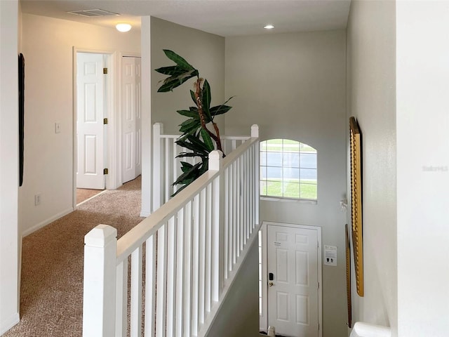 hall with light colored carpet